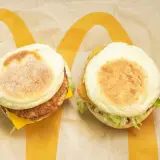 Dwa McMuffiny na papierze McDonald's. Jeden z kotletem i serem, drugi z chrupiącym kurczakiem i sałatą. Zastanawiasz się, co ma najmniej kalorii w Mc?