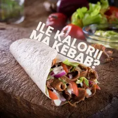 Kebab w tortilli z mięsem, warzywami i sosem na drewnianej desce.