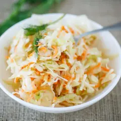 Chrupiąca sałatka do kebaba z kapusty i marchewki, udekorowana koperkiem. Idealny dodatek do ulubionego dania.
