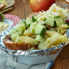 Kapsalon z frytkami, mięsem, serem, ogórkiem i surówką w folii aluminiowej.