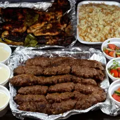 Pyszny kofta kebab z ryżem, sałatkami i sosami. Idealny posiłek dla miłośników mięsa.