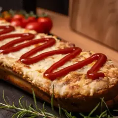 Pyszne, domowe zapiekanki z piekarnika, z ciągnącym się serem i ketchupem, podane z gałązką rozmarynu.