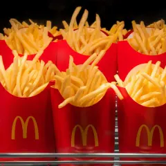 Kilka czerwonych opakowań McDonald's wypełnionych średnimi frytkami.