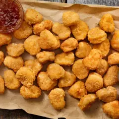 Chrupiące kawałki kurczaka w panierce kfc oryginalny przepis, podane z sosem.
