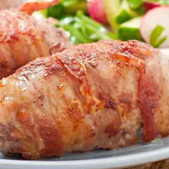 Soczysty kurczak grillowany zawinięty w boczek, podany z chrupiącą sałatką z ogórka i rzodkiewki.