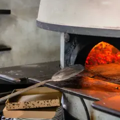 Piec do pizzy z żarem i łopatą do pizzy.