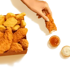Pudełko McDonald's z kurczakiem, frytkami i sosami.