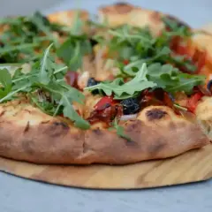 Pyszna pizza domowa na blachę, z ciasta na świeże drożdże, z rukolą i oliwkami.