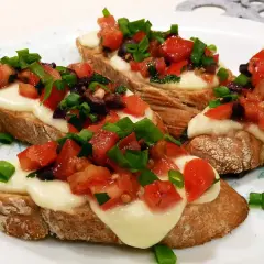 Bruschetta z pomidorami i mozzarellą, idealna na szybki przepis. Chrupiące grzanki z roztopionym serem, świeżymi pomidorami i szczypiorkiem.