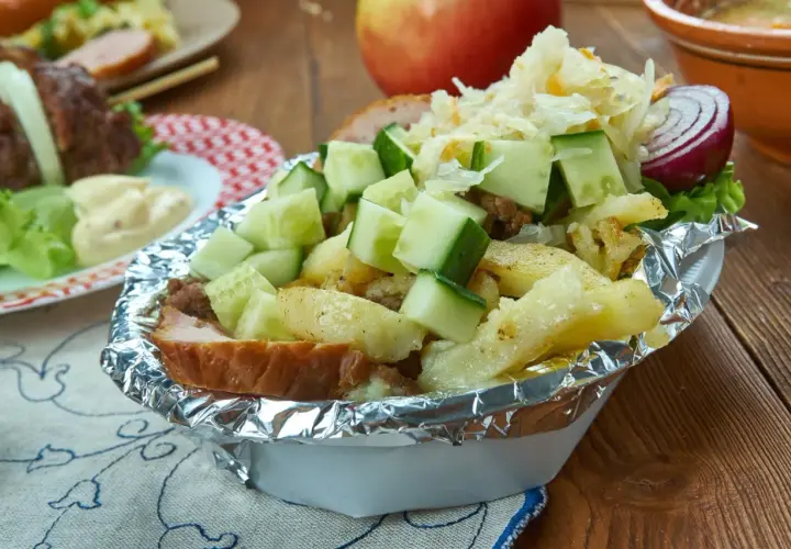 Kapsalon z frytkami, mięsem, serem, ogórkiem i surówką w folii aluminiowej.