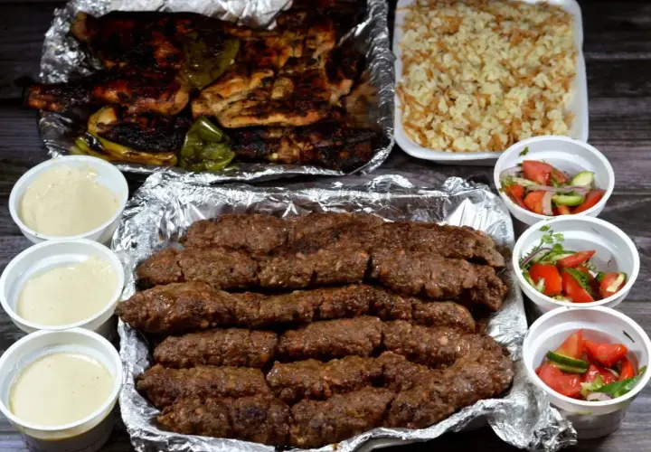 Pyszny kofta kebab z ryżem, sałatkami i sosami. Idealny posiłek dla miłośników mięsa.