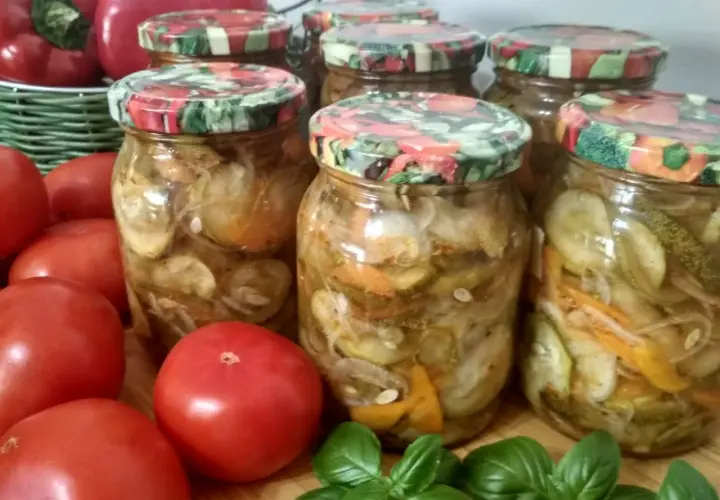 Słoiki z ogórkami w zalewie gyros, obok pomidory i papryka.
