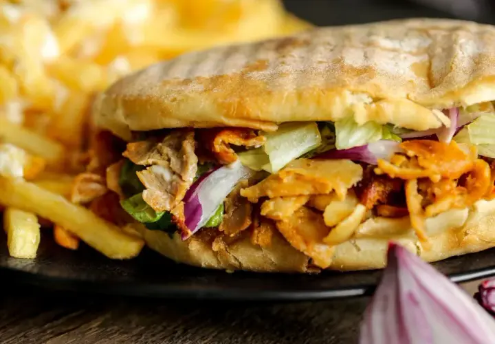 Knysza co to? Pyszna bułka z mięsem kebab, sałatą, cebulą i frytkami.