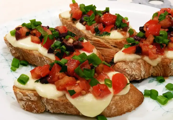 Bruschetta z pomidorami i mozzarellą, idealna na szybki przepis. Chrupiące grzanki z roztopionym serem, świeżymi pomidorami i szczypiorkiem.