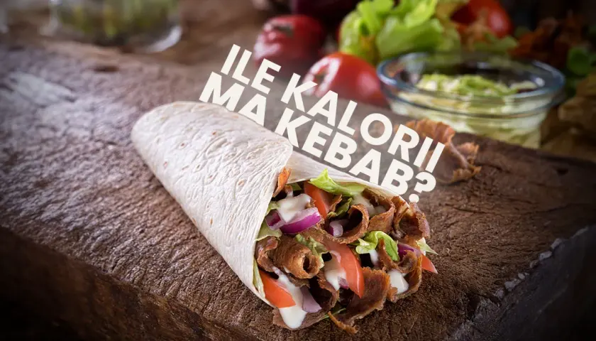 Kebab w tortilli z mięsem, warzywami i sosem na drewnianej desce.