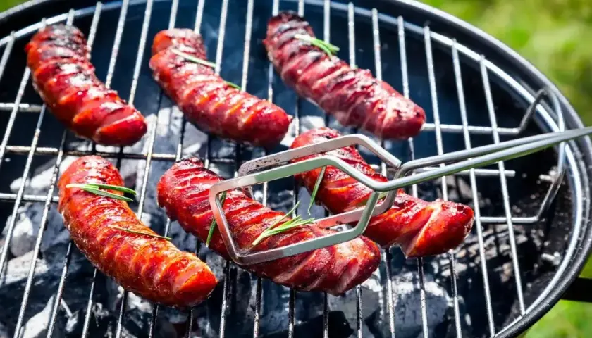 Pyszna kiełbasa z grilla, rumiana i soczysta, z gałązkami rozmarynu, gotowa do podania.