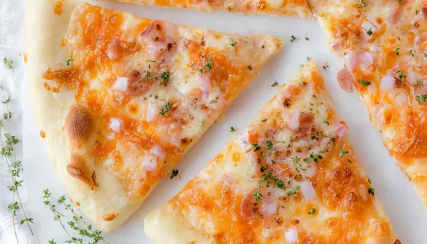 Kawałki pysznej pizzy z twarogu, posypane ziołami i kawałkami cebuli.