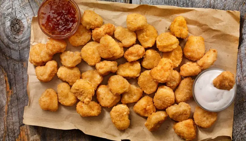 Chrupiące kawałki kurczaka w panierce kfc oryginalny przepis, podane z sosem.