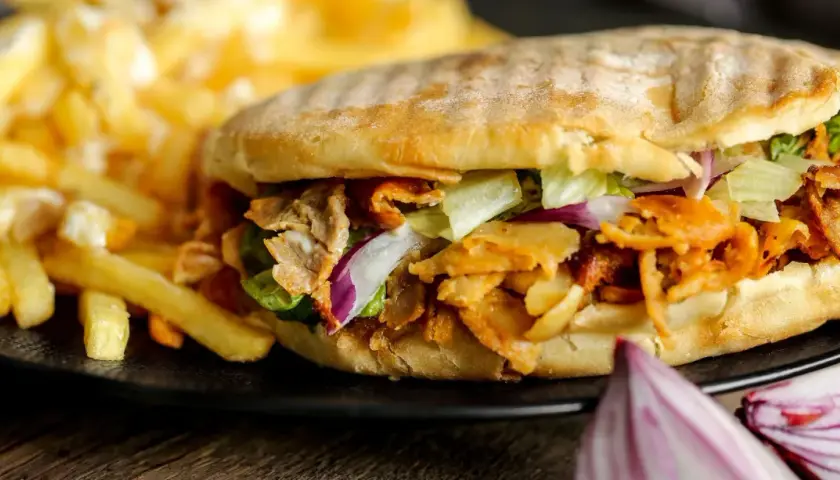 Knysza co to? Pyszna bułka z mięsem kebab, sałatą, cebulą i frytkami.