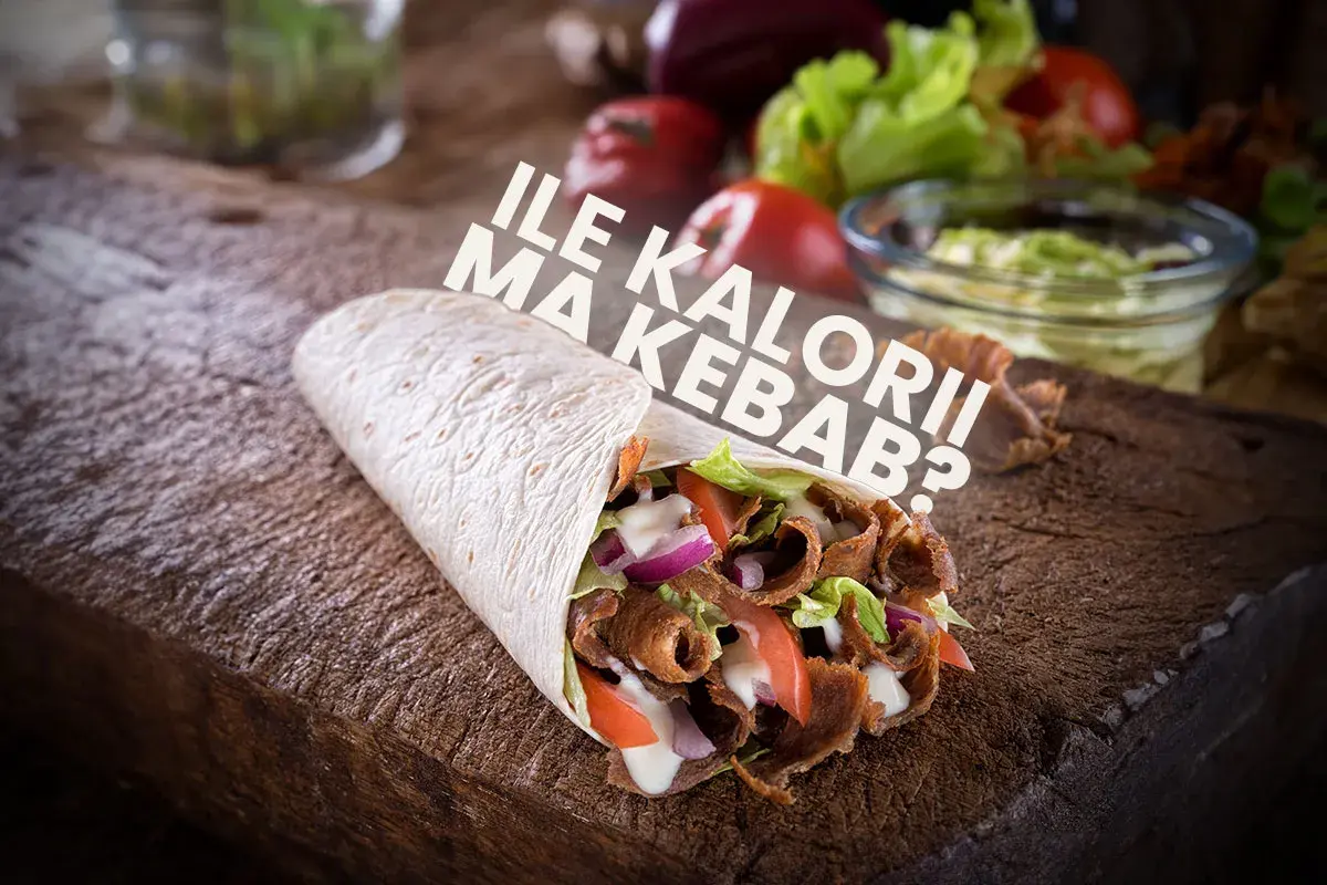 Kebab w tortilli z mięsem, warzywami i sosem na drewnianej desce.