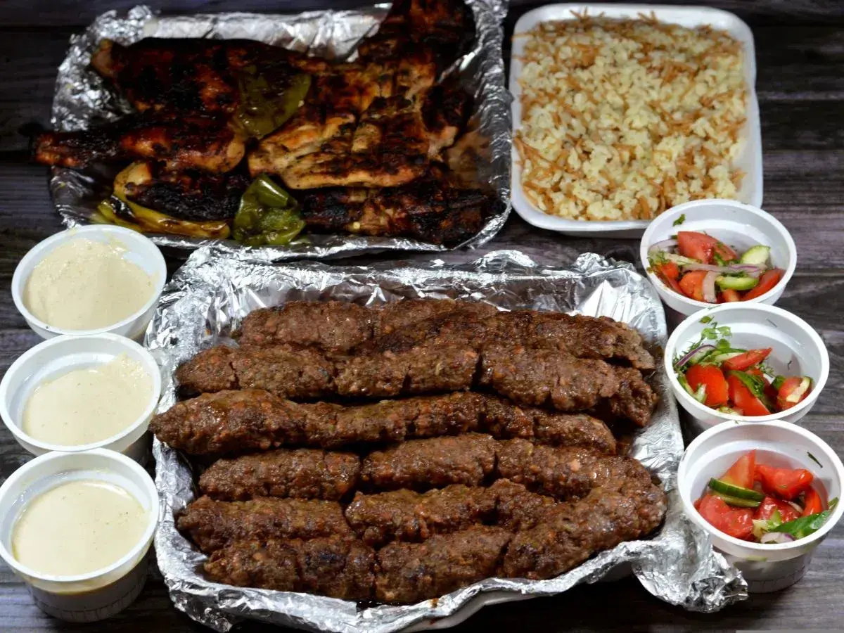 Pyszny kofta kebab z ryżem, sałatkami i sosami. Idealny posiłek dla miłośników mięsa.