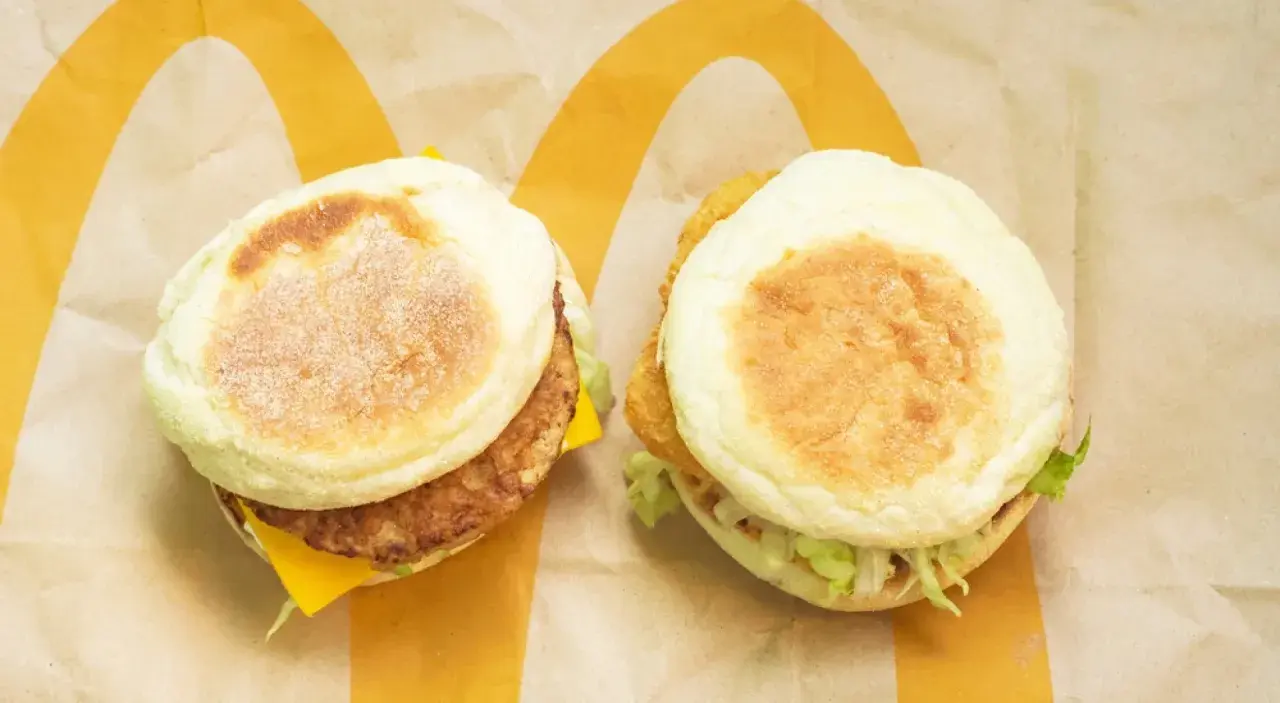Dwa muffiny z McDonald's, idealne na ofertę śniadaniową. Jeden z kotletem i serem, drugi z chrupiącym dodatkiem i sałatą.