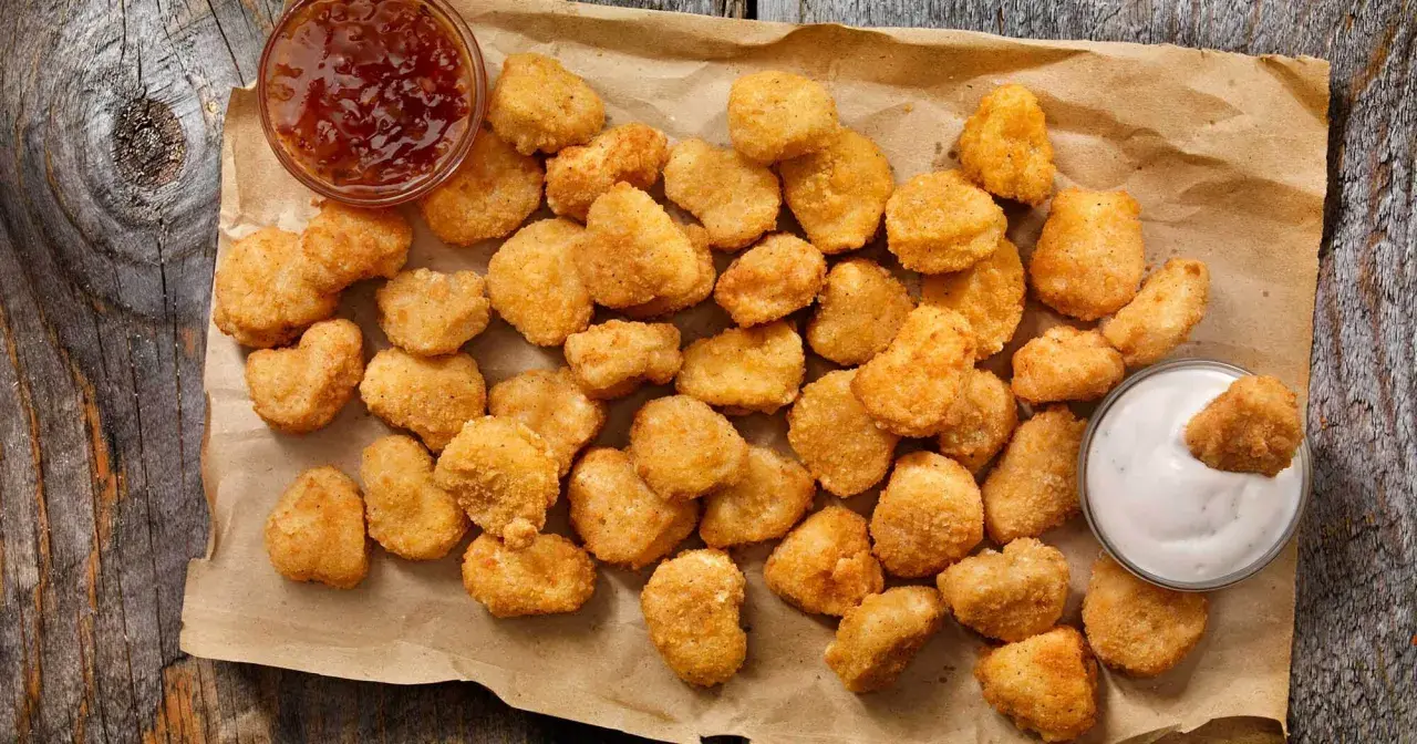 Chrupiące kawałki kurczaka w panierce kfc oryginalny przepis, podane z sosem.