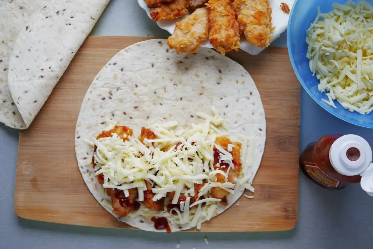 Qurrito przepis: tortille z kurczakiem, serem i sosem BBQ. Składniki gotowe do zwinięcia.