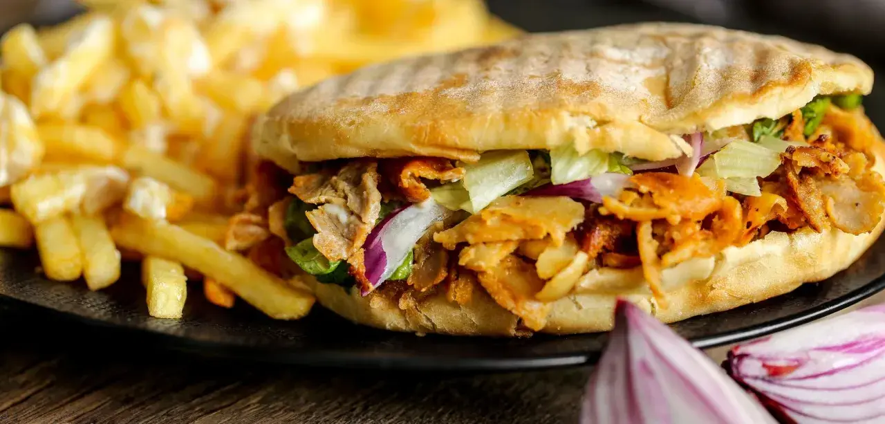 Knysza co to? Pyszna bułka z mięsem kebab, sałatą, cebulą i frytkami.