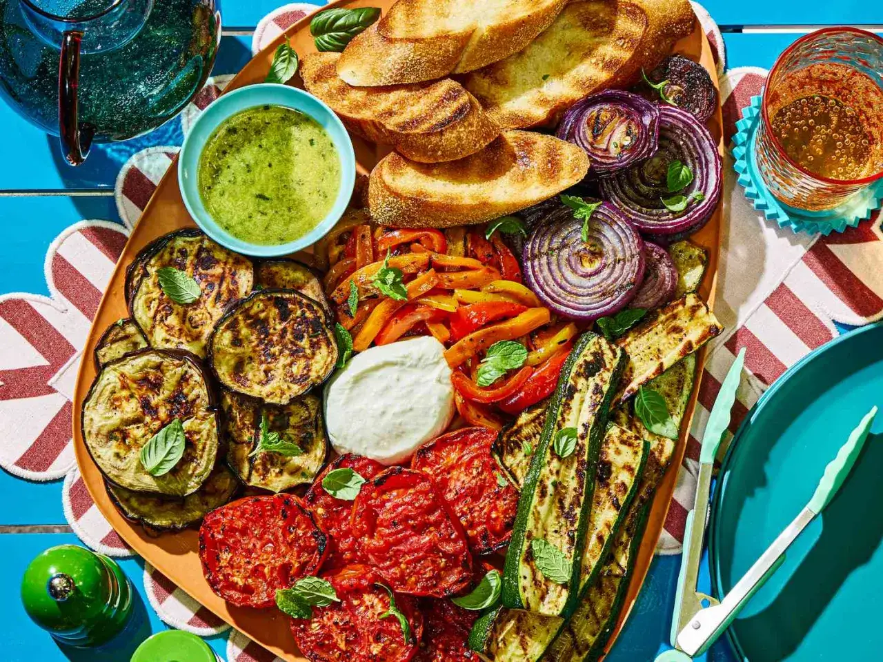 Pyszne przekąski na grilla: grillowane warzywa, pieczywo, sos i ser. Idealne na letnie spotkanie.