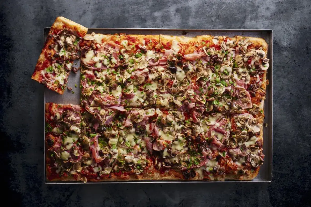 Domowa pizza na blachę z pieczarkami i szynką, idealna na rodzinny obiad. Przepis na puszyste ciasto ze świeżych drożdży.