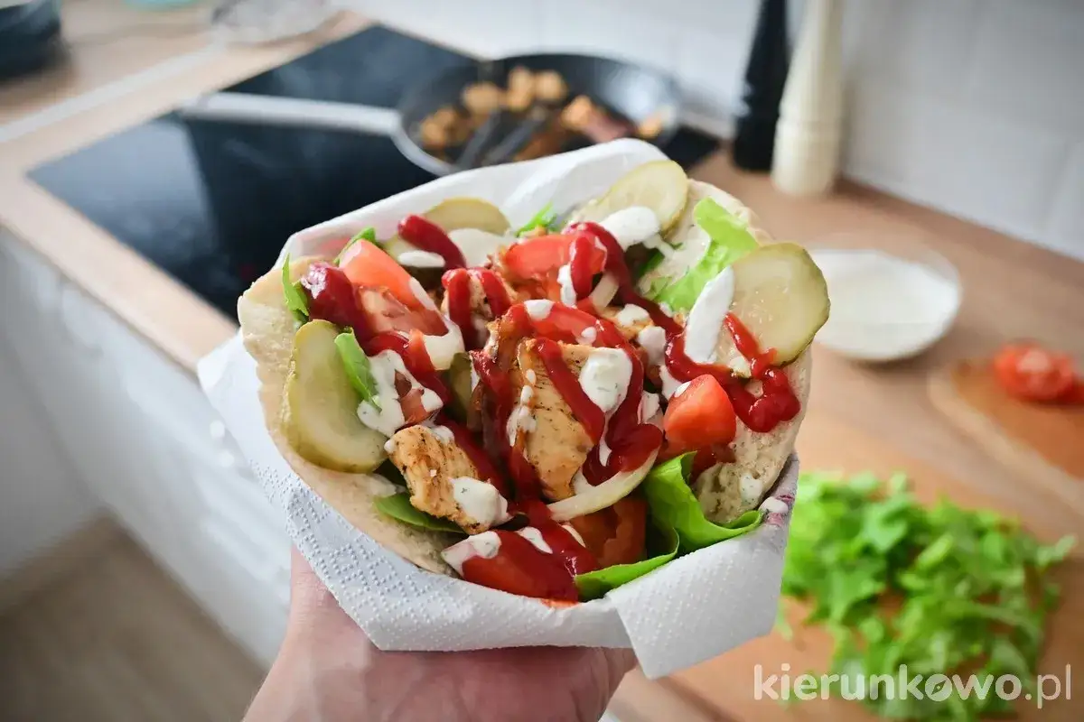 Pyszny kebab w picie z kurczakiem, warzywami i sosami, gotowy do zjedzenia.