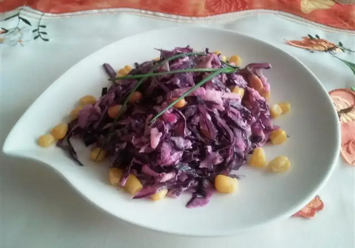 Wykwintna surówka z czerwonej kapusty z kukurydzą, niczym z restauracji, udekorowana szczypiorkiem.
