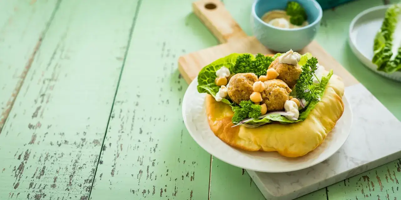 Pyszne falafel w picie z sałatą, ciecierzycą i sosem. Idealne danie, gdy zastanawiasz się, co to jest falafel.