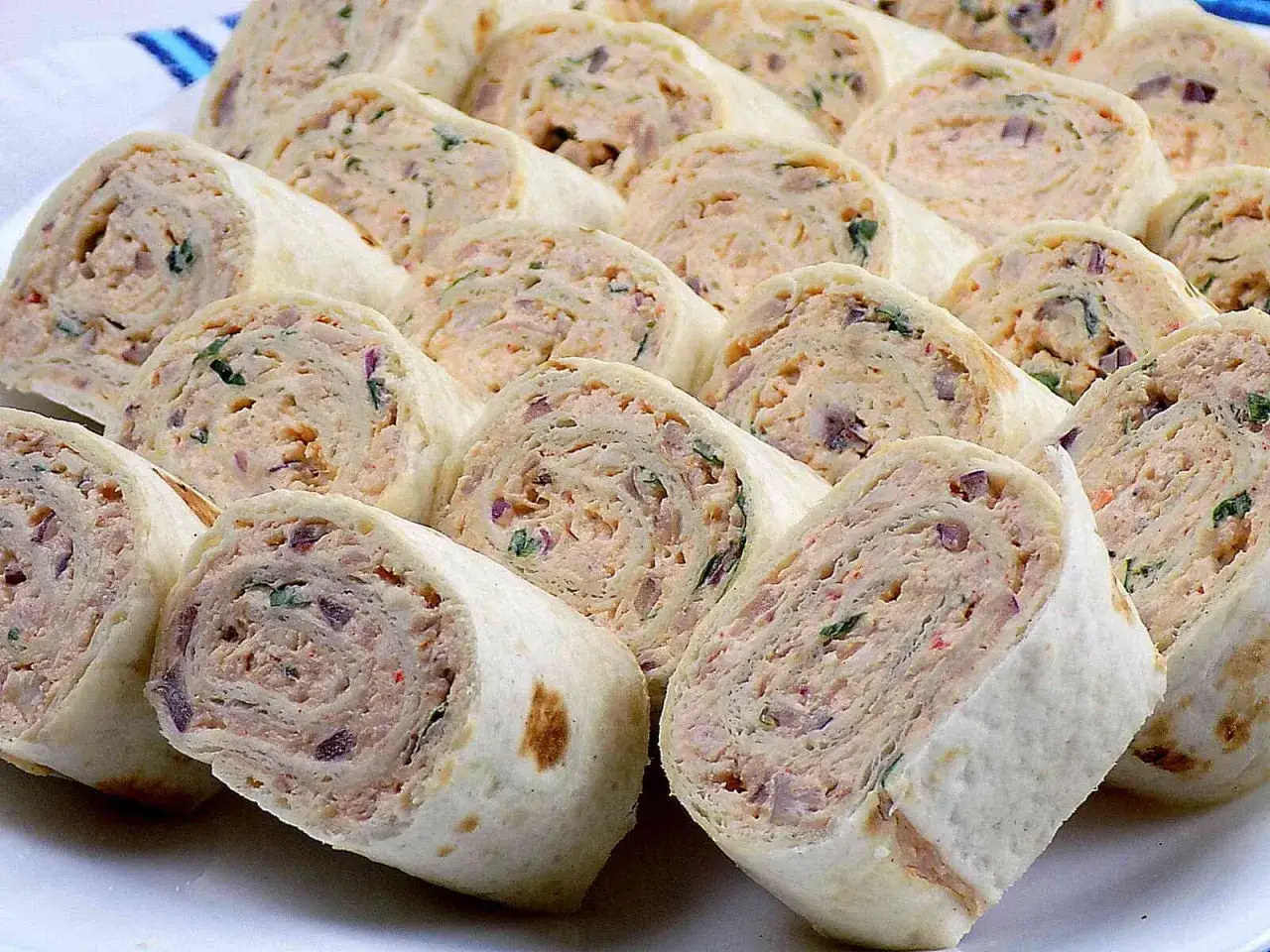 Szybkie przekąski z tortilli na zimno, pokrojone w krążki, z kremowym nadzieniem i ziołami. Idealne na imprezę lub jako lekki posiłek.
