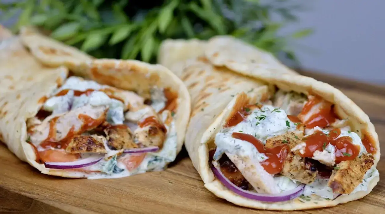 Dwa pyszne wrapy z kurczakiem gyros, polane sosem jogurtowym i keczupem, z dodatkiem warzyw.
