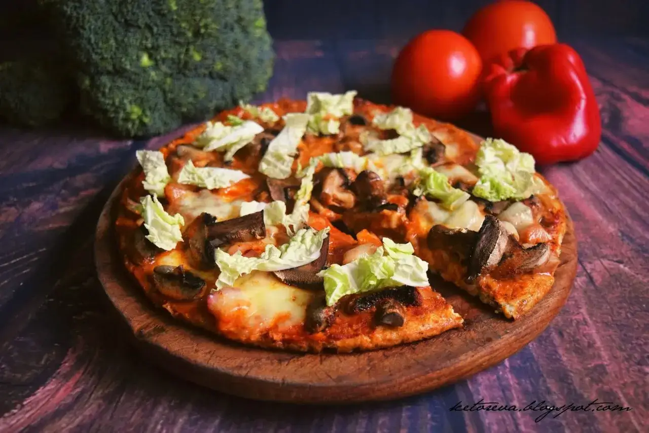 Pyszna pizza z twarogu z pieczarkami i kapustą pekińską, na tle brokułów i pomidorów.